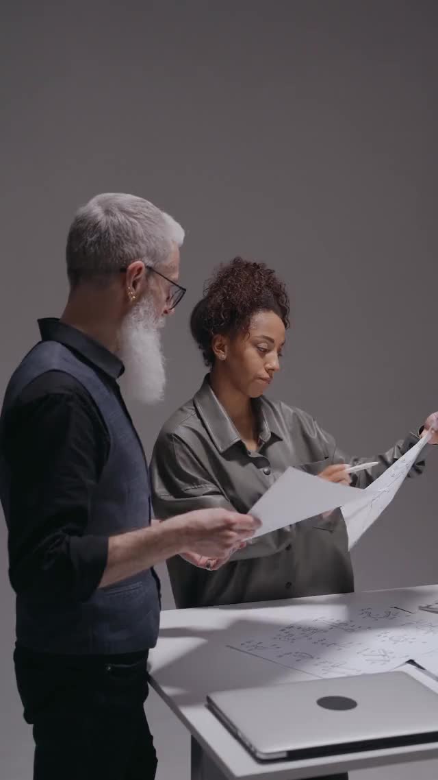Licensed stock scene of two adult colleagues discussing documents